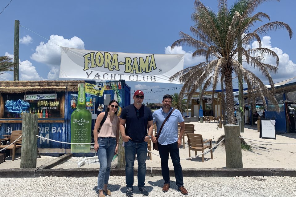 Three members of the Tempest team pose for a photo in front of the Flora-Bama Yacht Club in Pensacola, Florida.