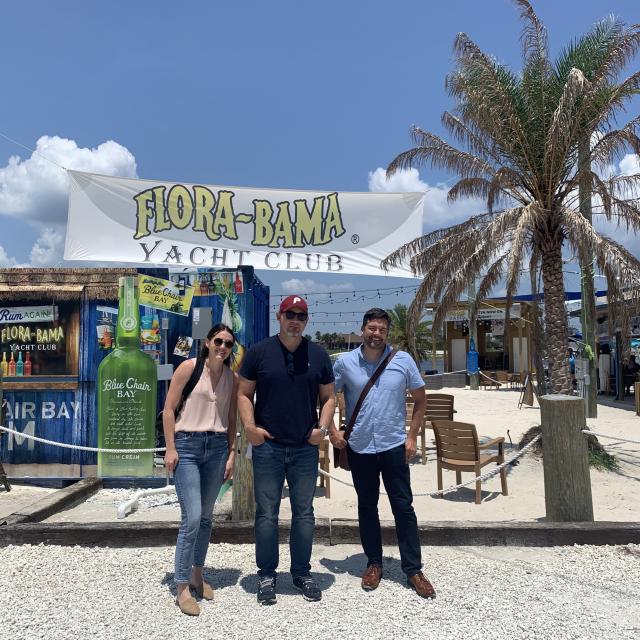 Three members of the Tempest team pose for a photo in front of the Flora-Bama Yacht Club in Pensacola, Florida.